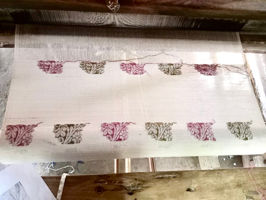a silk scarf being woven on a traditional handloom in assam india