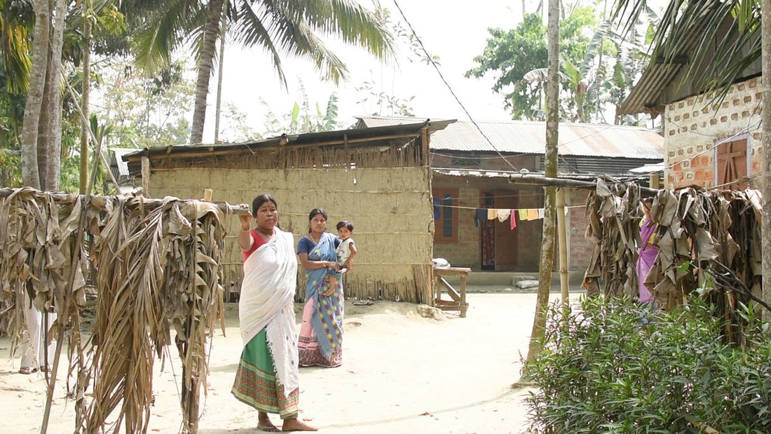 women weavers standing in front of their home in rural Assam