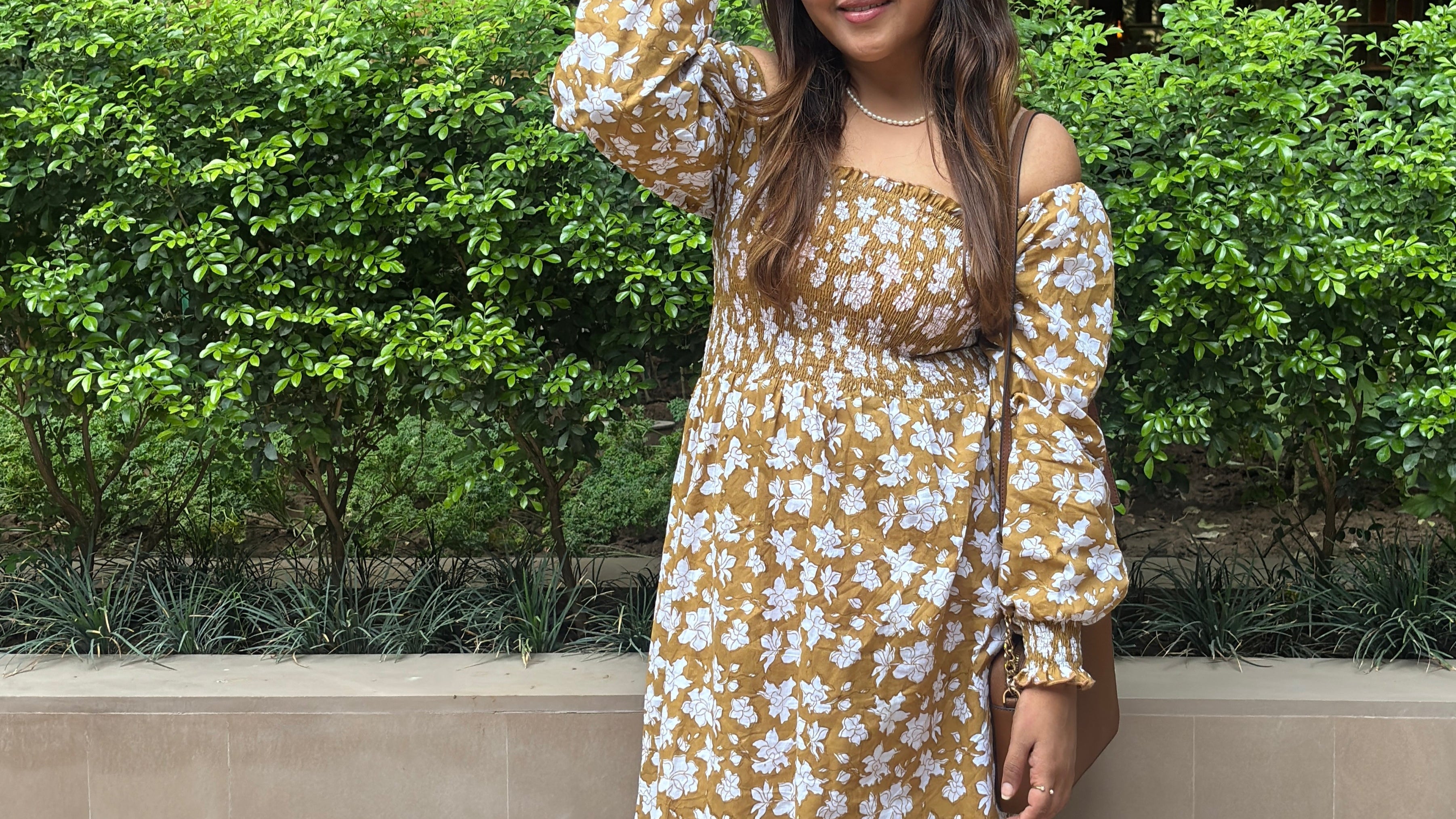 Woman in a earthy brown floral dress by the brand Arras