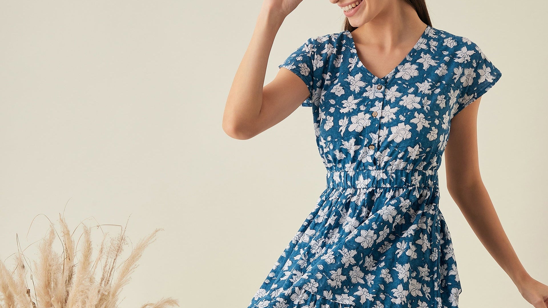Woman wearing a blue floral printed dress against a neutral background